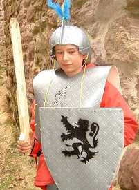 Knight’s armour made from PVC ground sheet with a shield with a PVC logo glued on, Wooden sword and a helmet made from an old ball.