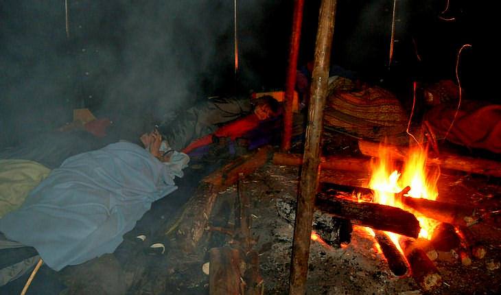 In a fire tent with sleeping bags around the camp fire